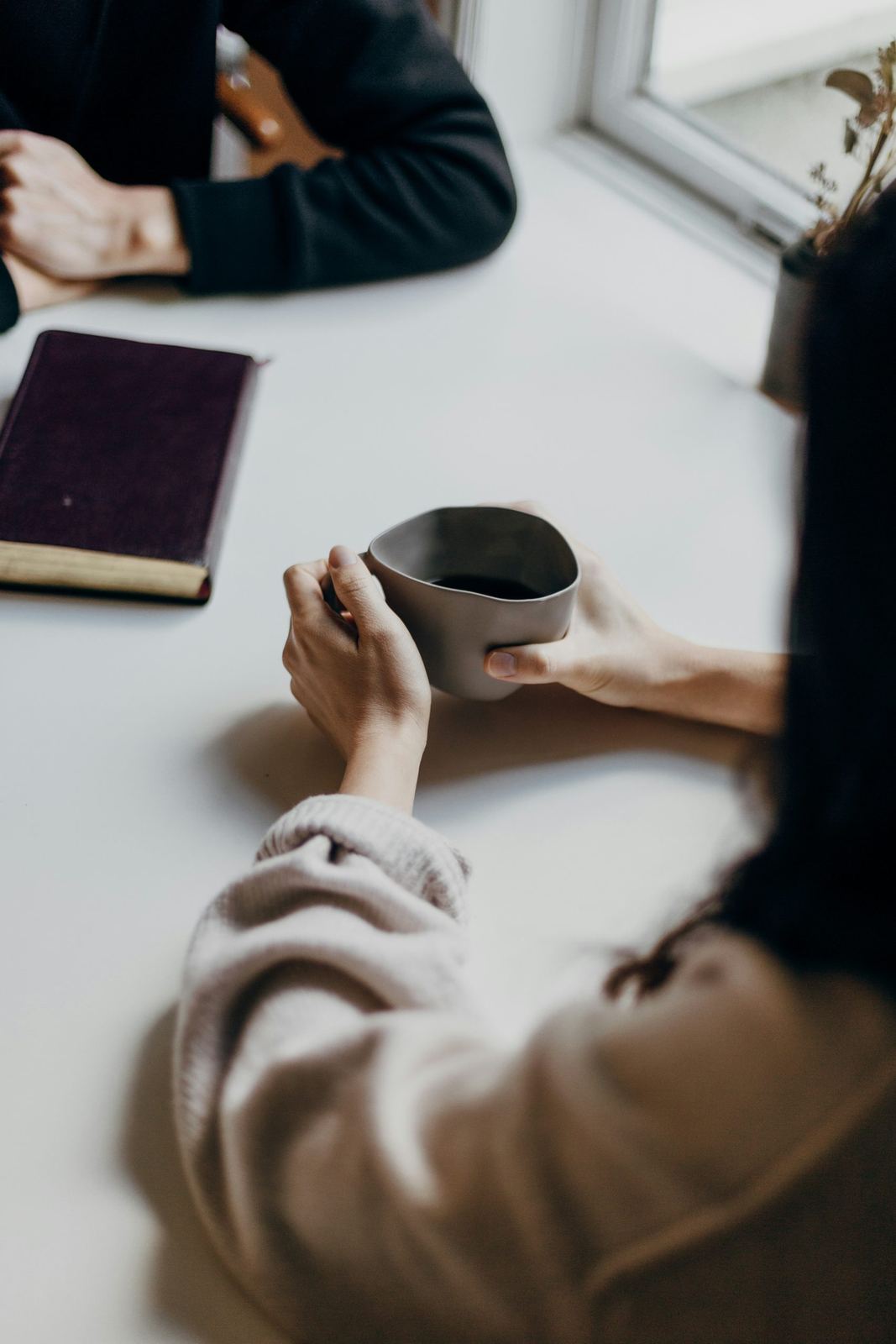 An image of a woman holding a mug of a warm drink