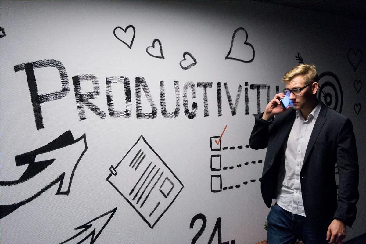 An image of a man on the phone thinking he needs to be more productive.