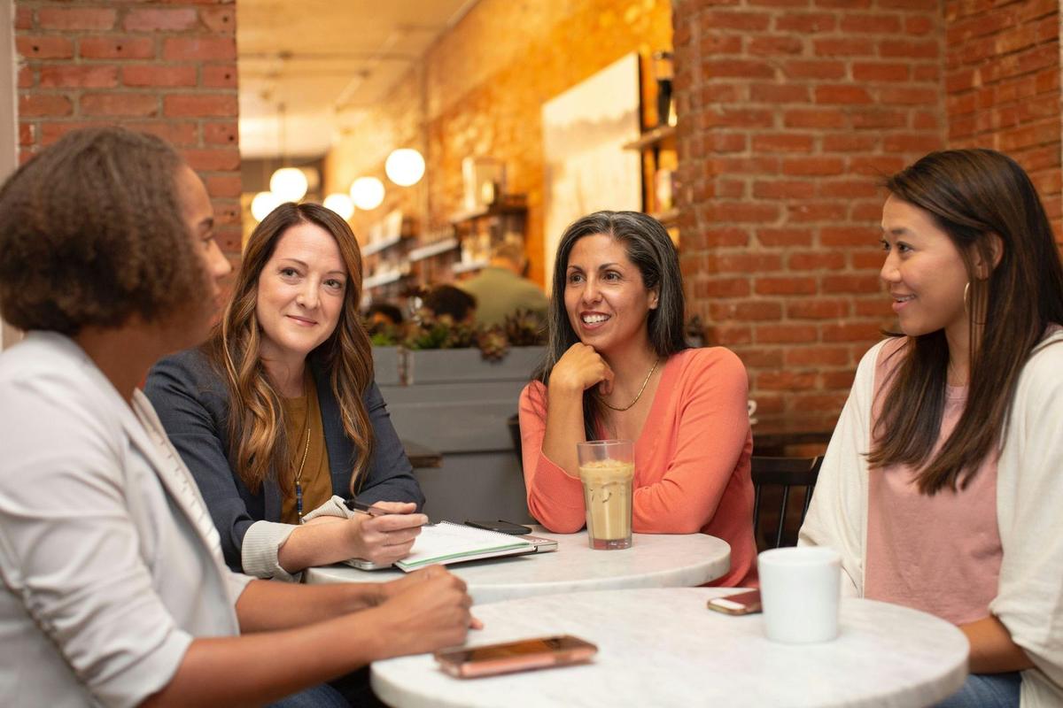 an image of 4 women different ages and ethnicities catching up after work