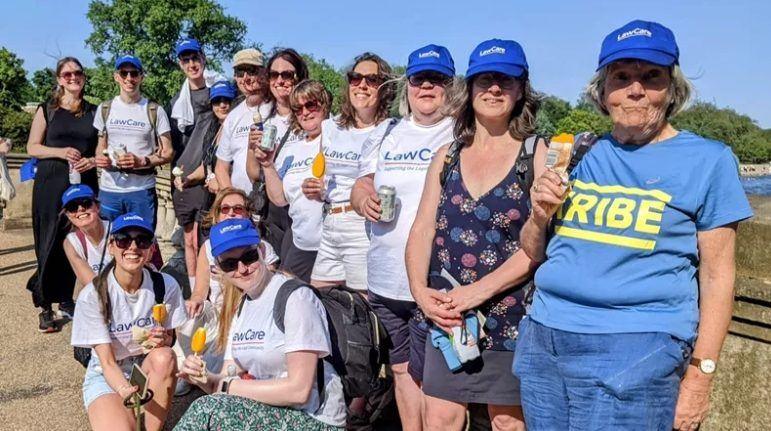 women and men gathered at the end of a legal walk enjoying a drink and ice cream