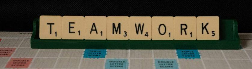 A picture of a scrabble board with scrabble tiles spelling teamwork - collaborative legal practice