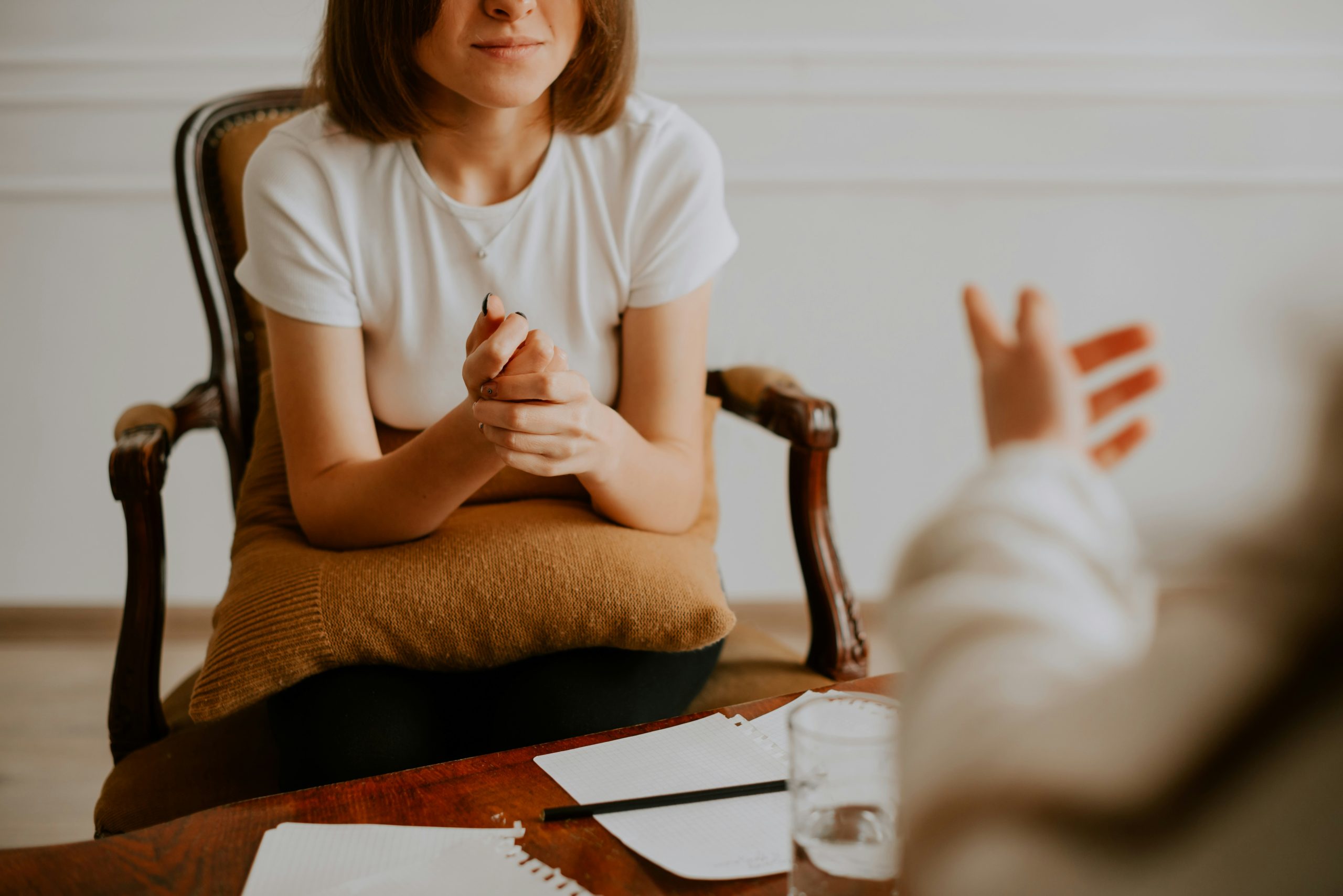 An image of a woman sat on a chair in atherapy session