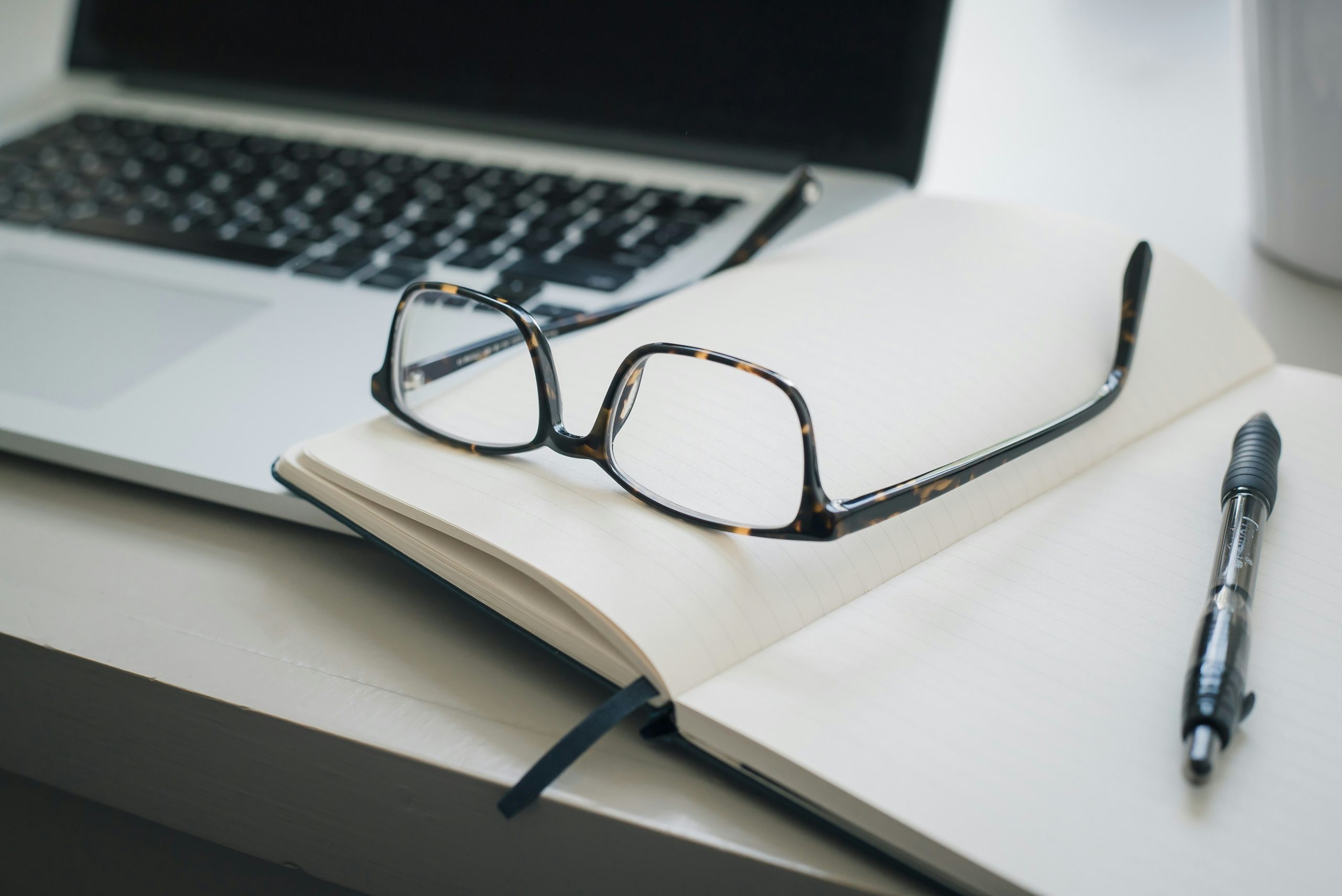 An image of black frame glasses on a notepad